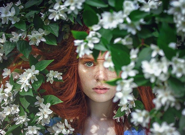 Chica con flores al fondo